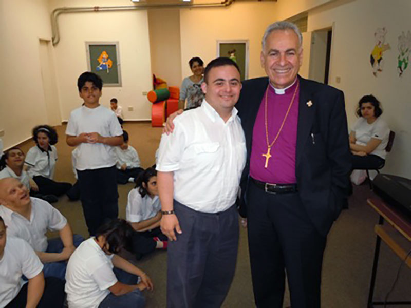 A photo of AFEDJ Trustee, The Most Rev. Suheil Dawani and a student at St. Luke's Center for Rehabilitation in Beirut, Lebanon