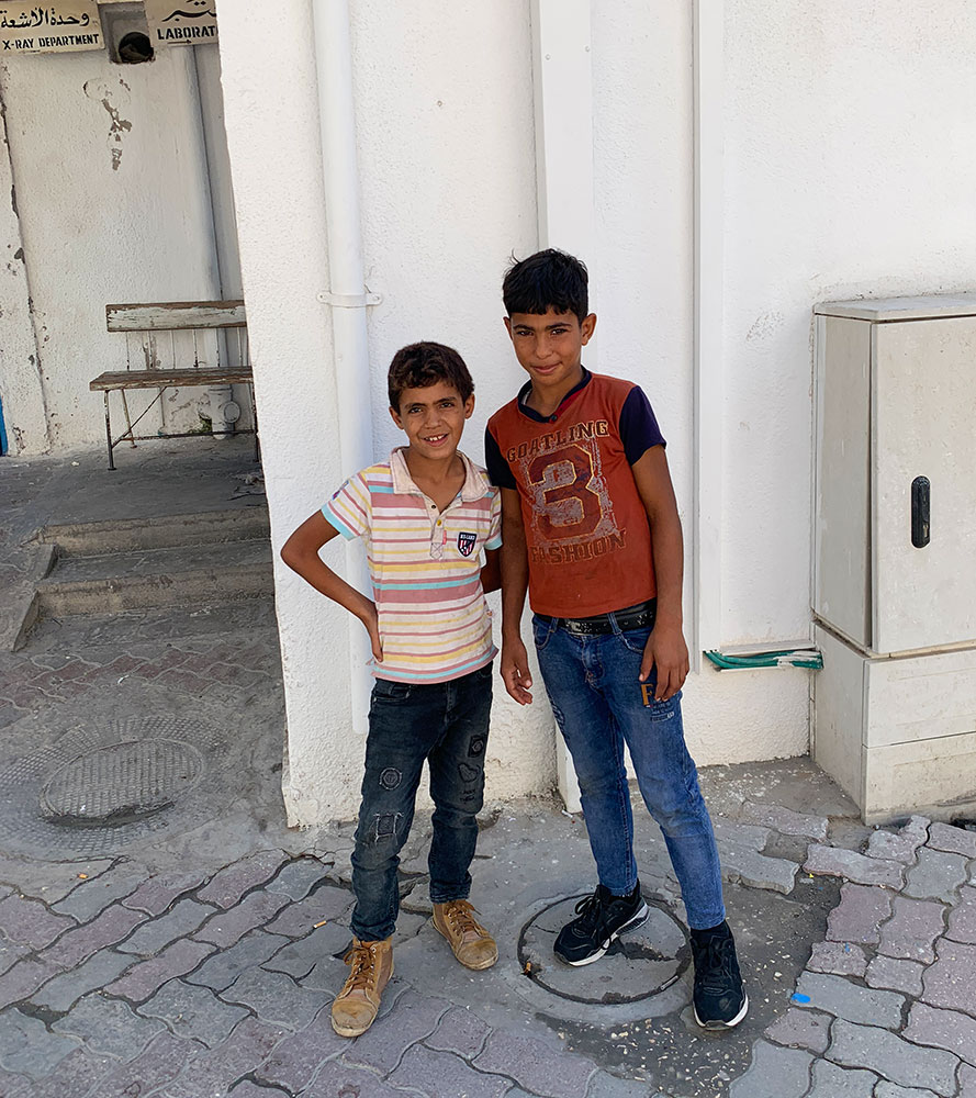 A photo of two boys standing outside Ahli Arab Hospital.